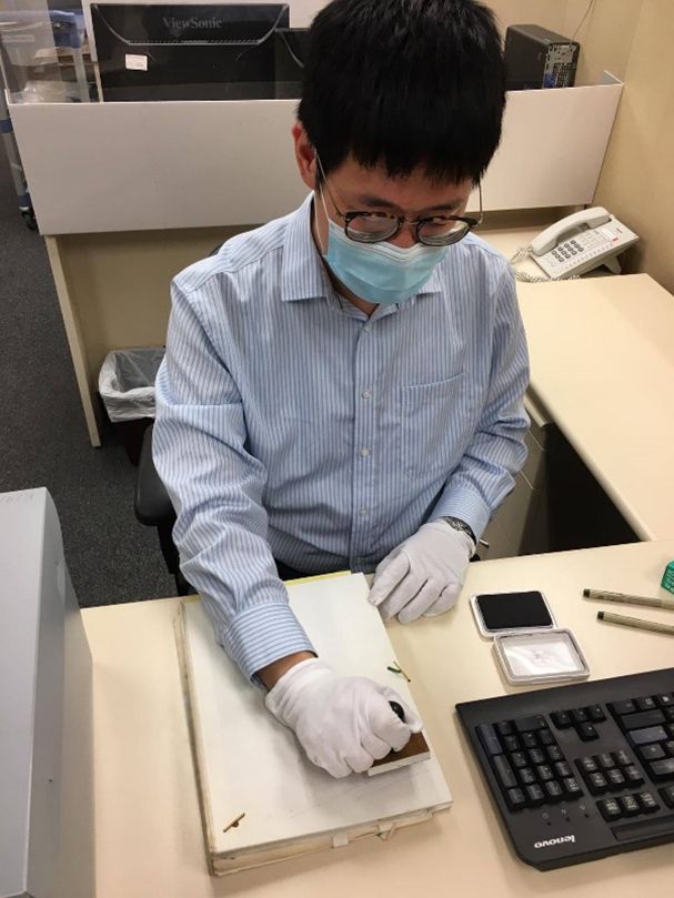 Mr Tse stamping a record being accessioned