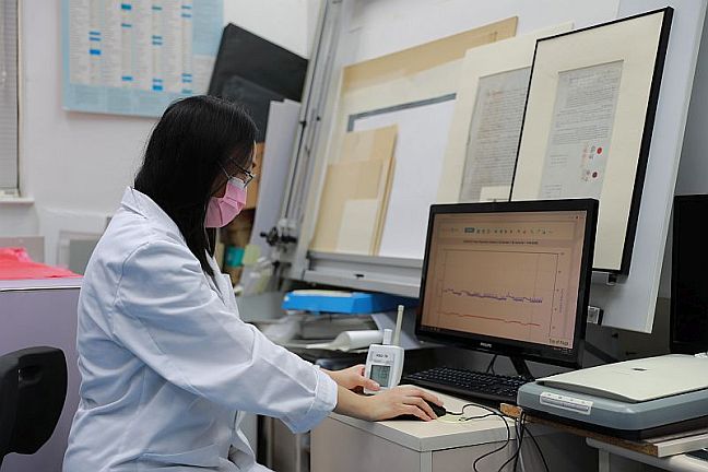 Ms Lo checking the humidity and temperature monitor of the repository